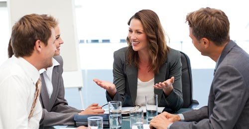 Attractive businesswoman laughing with her team during a meeting