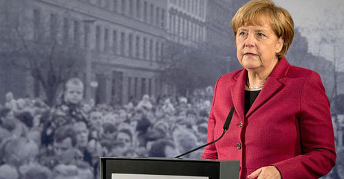 BER819. Berlin (Germany), 09/11/2014.- German Chancellor Angela Merkel stands in front of a historic black and white photograph depicting the opening of the inner-city border at Bernauer Strasse in 1989 during the central commemorative event at the Berlin Wall Memorial Bernauer Strasse marking the 25th anniversary of the fall of the Berlin Wall, in Berlin, 09 November 2014. Germany marked the 25th anniversary of the fall of the Berlin Wall on 09 November with a series of commemorative and cultural events. One of them will be the release of about 8,000 illuminated helium balloons, arranged along 15-kilometres that traced the path of the former Cold War barrier through the centre of nation's capital, into the night sky over Berlin. (Alemania) EFE/EPA/SOEREN STACHE
