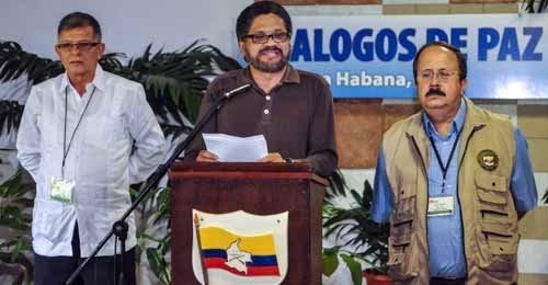 Commander Ivan Marquez (C), head of the Revolutionary Armed Forces of Colombia (FARC-EP) leftist guerrillas delegation for the peace talks with the Colombian government, reads a document to the media next to Commander Rodrigo Granda (L), and Commander Andres Paris at the Convention Palace in Havana on October 3, 2013, at the end of a new round of meetings with the Colombian government delegation. The Colombian government resumed peace talks with leftist rebels Thursday in a renewed bid to end nearly half a century of armed conflict. Negotiations, which began in November, picked up again in the Cuban capital following a two-week break.    AFP PHOTO/ADALBERTO ROQUE