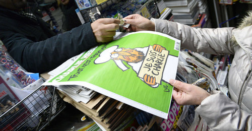 People wait outside a newsagents in Paris on January 14, 2015 as a customer buys the latest edition of French satirical magazine Charlie Hebdo shortly after it went on sale. The first issue of satirical magazine Charlie Hebdo to be published since a jihadist attack decimated its editorial staff last week was sold out within minutes at kiosks across France. AFP PHOTO / BERTRAND GUAY